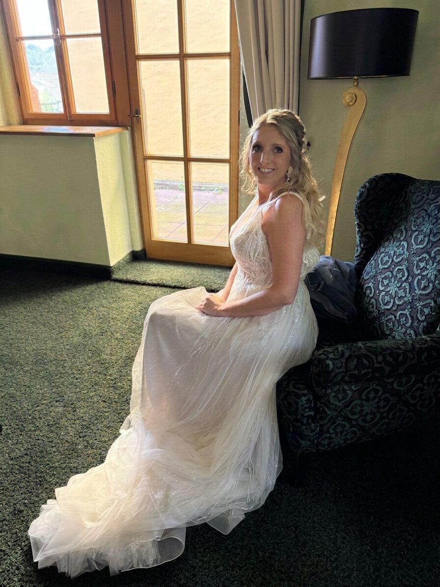 Vorderansicht der Braut im Brautkleid, halboffene Steckfrisur, Brautfrisur romantisch mit Locken und Extensions
